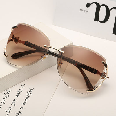 Oversized rimless sunglasses with gradient gray lenses and silver-tone metal accents, displayed on a white surface. - Image 9
