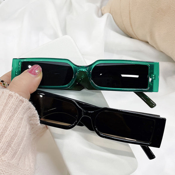 Black rectangular vintage small frame sunglasses with dark gray lenses on a white background.
