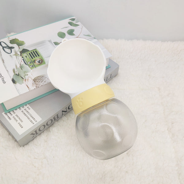 Portable pet water bottle with white drinking bowl, translucent grey reservoir, and yellow paw print band. - Image 3