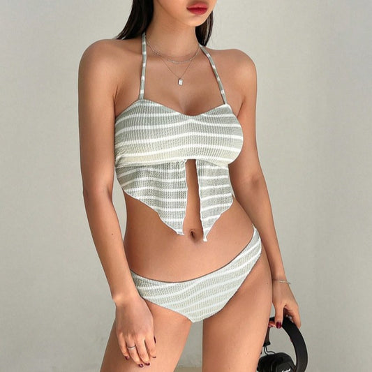 Woman in a light green and white striped two-piece swimsuit with a halter top and V-cut front hem.