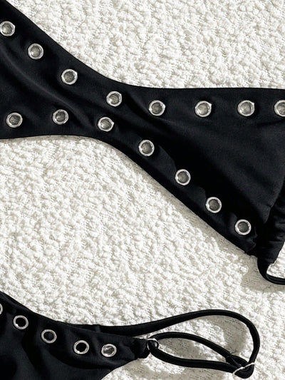 Black bandeau bikini swimsuit with thin straps and a gold-toned abstract ring detail on the top, paired with matching string bottoms. - Image 40