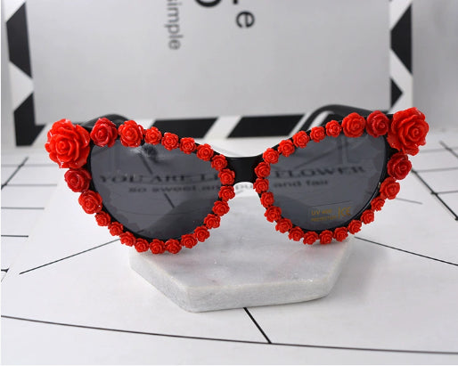 Black cat-eye sunglasses with dark lenses, adorned with small red rose embellishments along the frames. - Image 6