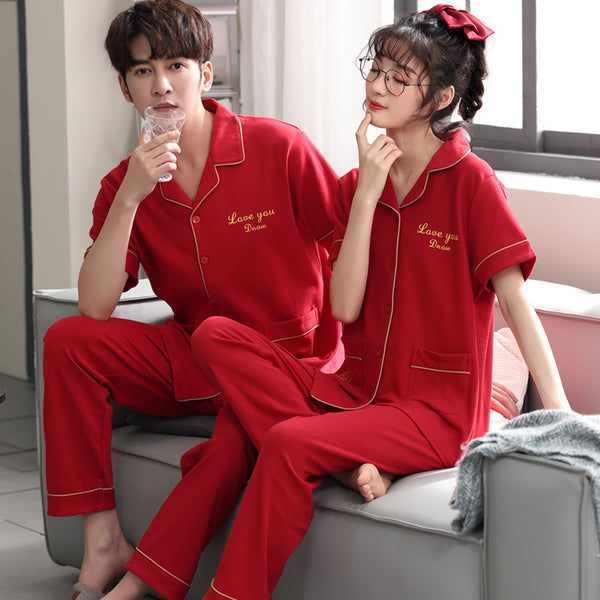 Matching red cotton couple pajamas with short sleeves, long pants, gold piping, and "Love you Dnaw" embroidery.