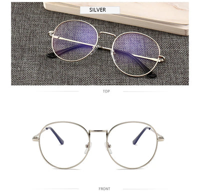 Black round anti-blue light glasses with clear lenses showing a blue reflection, resting on a gray textured surface. - Image 11