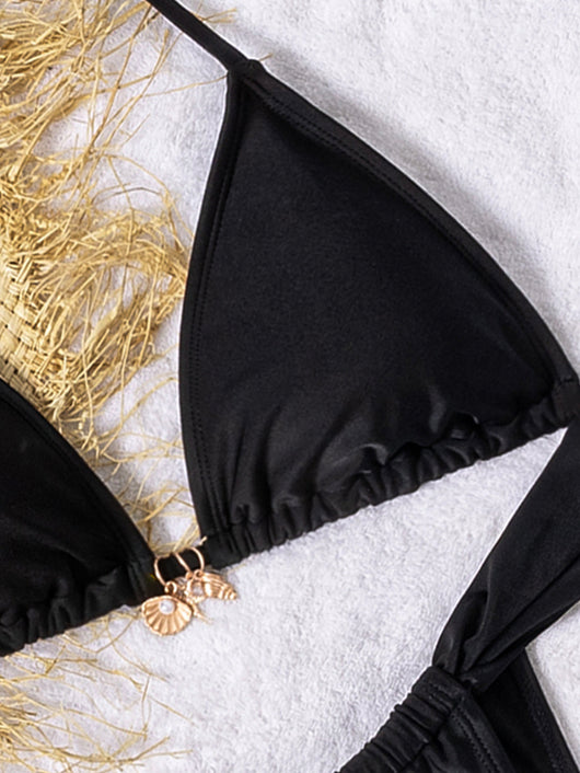 Black solid-color triangle-bra swimsuit with tie-front bikini bottom on a white towel with beach accessories. - Image 16