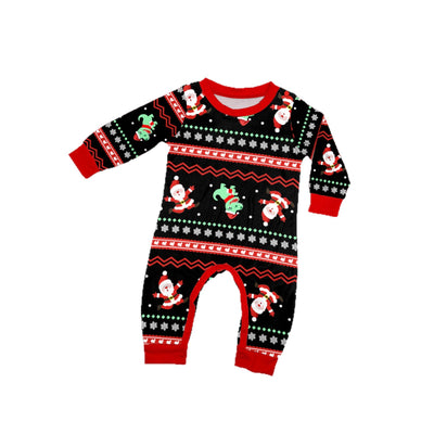 Man wearing black Christmas pajamas with a cartoon dinosaur, Santa Claus, and "Merry Christmas" text, standing by a decorated tree. - Image 5