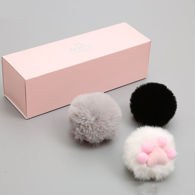 Three fluffy cat toy balls in white with pink paw print, gray, and black, next to a pink gift box. - Image 5