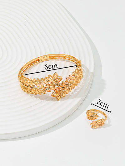 Gold wheat ear leaf cuff bracelet and matching open ring set on a white textured surface. - Image 5