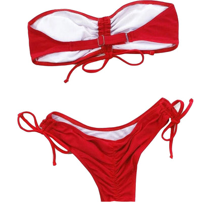Red two-piece bikini with a strapless ruched bandeau top and matching side-tie bottoms, displayed on a white surface. - Image 16