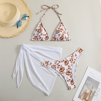 White and yellow floral print three-piece bikini set with a halter triangle top, high-cut bottom, and sheer white sarong. - Image 7