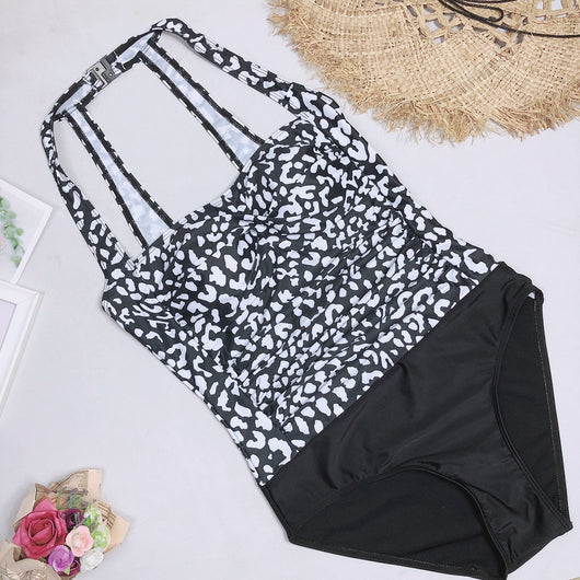 Woman in a black and white leopard print one-piece swimsuit with a halter neck and black bottoms, wearing sunglasses. - Image 12