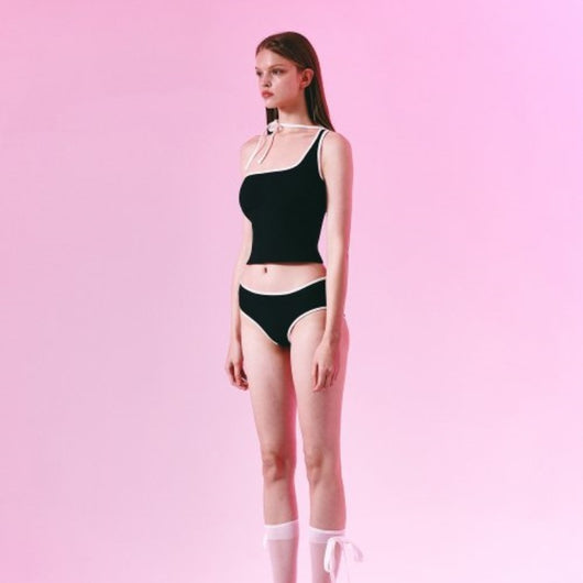Women's light purple one-shoulder swimsuit with dark red contrast trim, lying on a striped blanket on green grass. - Image 3