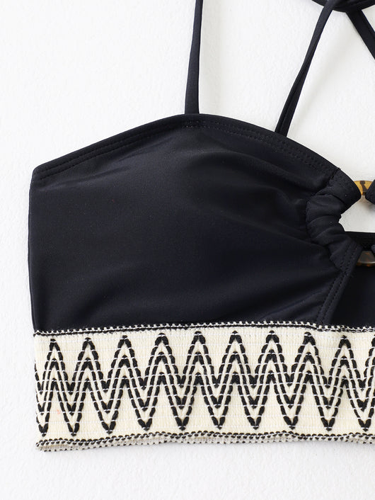 Black two-piece swimsuit with a bandeau top featuring a central O-ring, cut-out, and white zigzag embroidered trim, paired with matching high-cut bikini bottoms - Image 8