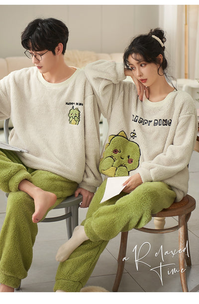 Couple wearing matching cream coral fleece pajamas with gray pants and bear embroidery, seated on a bed. - Image 20