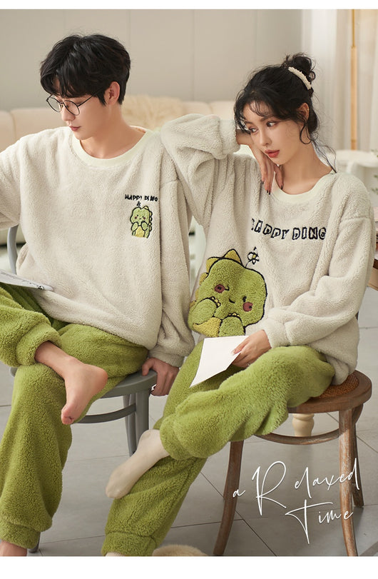 Couple wearing matching cream coral fleece pajamas with gray pants and bear embroidery, seated on a bed. - Image 20