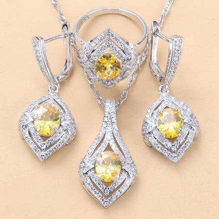 Silver-toned three-piece jewelry set with clear oval and round gems, including a necklace, dangle earrings, and a ring. - Image 12