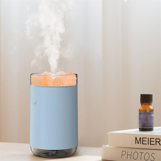 Pink cylindrical humidifier and essential oil diffuser with glowing orange crystal salt stones and a clear base. - Image 6