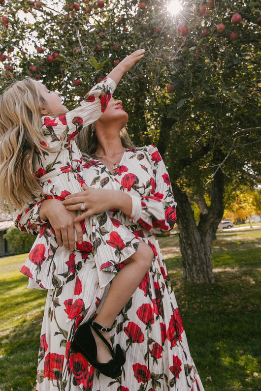 Mother and daughter in matching white dresses with red floral print, V-neck, long sleeves, and tie-waist. - Image 15