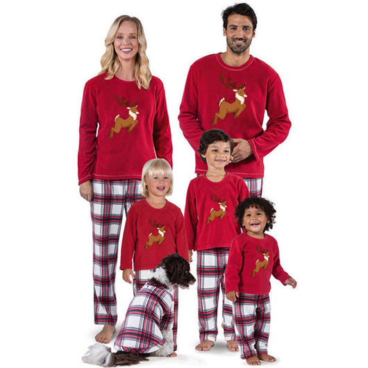 Family of five and a dog wearing matching red long-sleeve reindeer print tops and red and white plaid pajama pants. - Image 14