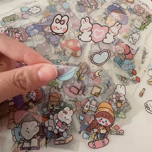 Stack of clear PET journal stickers with cartoon designs, including a character in a purple bunny suit, lemons, and desserts. - Image 2