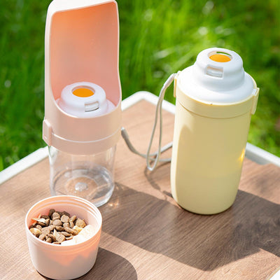 White 2-in-1 travel dog water bottle and food dispenser with a clear compartment and gray lanyard for pets. - Image 3