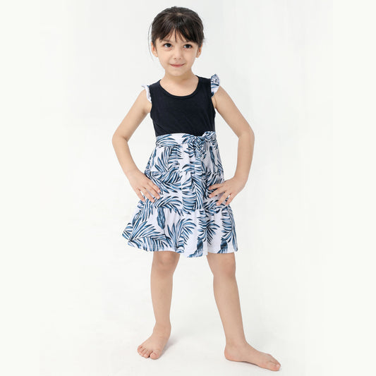 Young boy wearing a white short-sleeve t-shirt with blue tropical leaf print and a black chest pocket. - Image 2