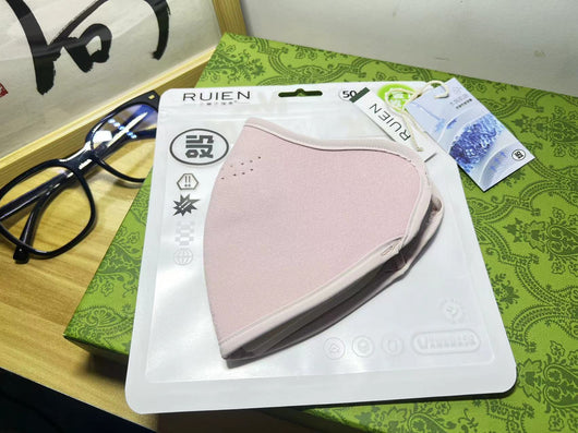 Dark gray cotton head-mounted mask with adjustable ear loops, shown in packaging on a patterned green surface. - Image 16