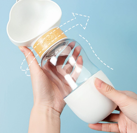 Yellow and clear portable pet water bottle with integrated drinking bowl and separate food container for walking dogs. - Image 25