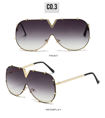 Oversized V-shaped sunglasses with a gold metal frame, white accents, clear lenses, and decorative rivets. - Image 23