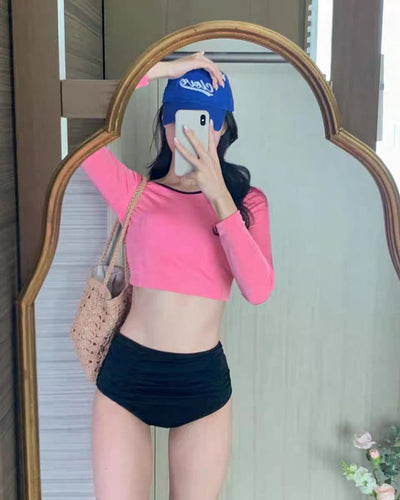 Woman in a pink long-sleeved crop top and black high-waisted ruched swim bottoms, posing in a mirror. - Image 12