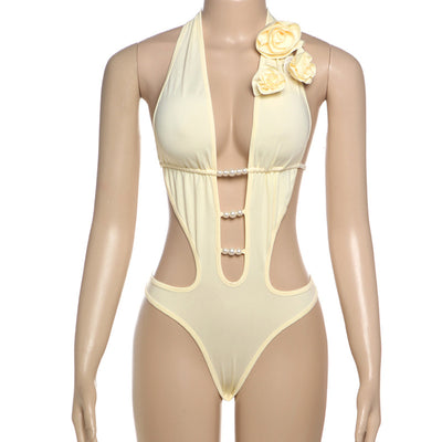 White halter monokini with deep V-neck, side cut-outs, and pearl bead embellishments on a woman at the beach. - Image 61
