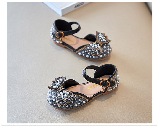 Beige girls' shallow mouth pumps with a large pink pearl bow, glitter, and an ankle strap with a gold buckle. - Image 18