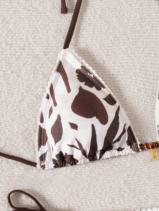 Brown and white floral print triangle bikini with tie-side bottoms and a small gold pendant detail. - Image 16