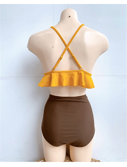 Woman in a yellow ruffled bikini top and dark brown high-waisted bottoms sitting on a beach. - Image 17