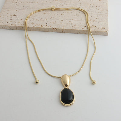 Pair of gold-toned irregular earrings with black onyx-like inserts, featuring a modern, abstract design. - Image 6