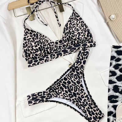 Leopard print high-waisted bikini with a halter neck top and front cutout, worn by a woman lounging outdoors. - Image 2