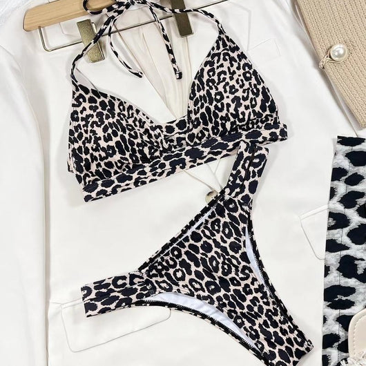 Leopard print high-waisted bikini with a halter neck top and front cutout, worn by a woman lounging outdoors. - Image 2