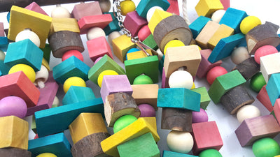 Colorful wooden parrot bite toy with a natural branch hanger and multiple strings of beads and blocks. - Image 3