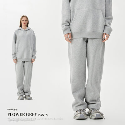 Young woman wearing a pink fleece-lined hoodie and matching sweatpants tracksuit set with a drawstring hood and kangaroo pocket. - Image 3