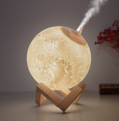 Moon-shaped humidifier and night light with a white deer stand, emitting mist, on a wooden table with books. - Image 9