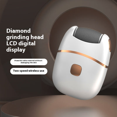 White and gold electric foot callus remover with a roller head, a replacement roller, cleaning brush, and USB cable.