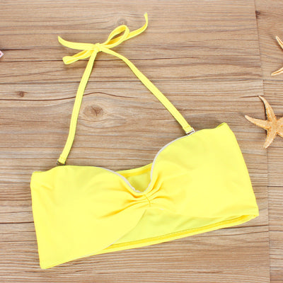 Women's two-piece swimsuit with a solid yellow bandeau top and black high-waisted bottoms with a vibrant abstract geometric pattern. - Image 2