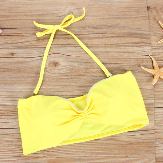 Women's two-piece swimsuit with a solid yellow bandeau top and black high-waisted bottoms with a vibrant abstract geometric pattern. - Image 2