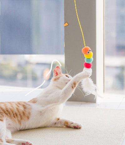 Colorful cat toy with pom-poms, googly eyes, white feathers, and a yellow elastic rope with a suction cup. - Image 5