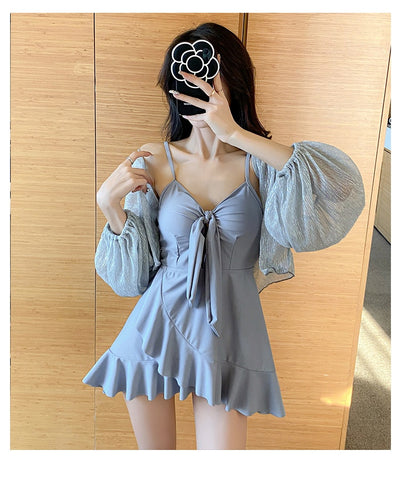 Women's light blue one-piece swimsuit with tie-front bust and ruffled hem, paired with a sheer shimmery cover-up. - Image 12