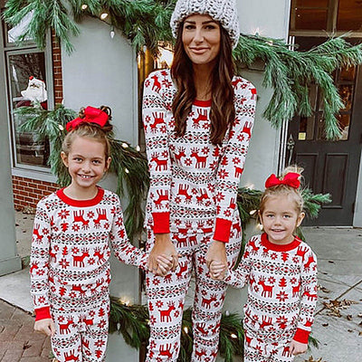 Mother and two daughters in matching red and white elk print long-sleeve pajamas, perfect for holiday family photos.