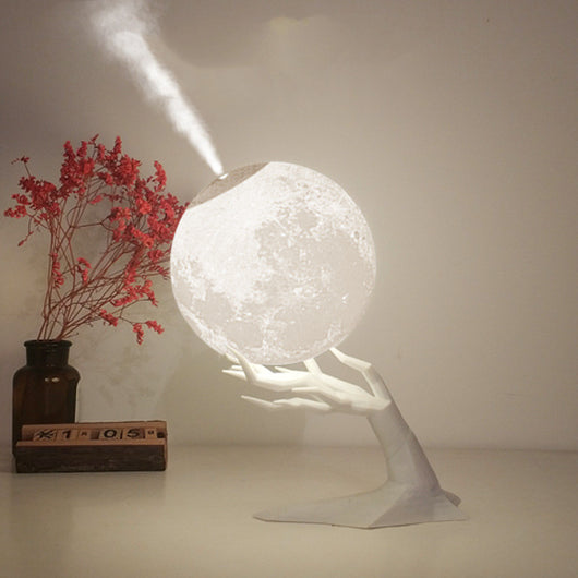 Moon-shaped humidifier and night light with a white deer stand, emitting mist, on a wooden table with books. - Image 5