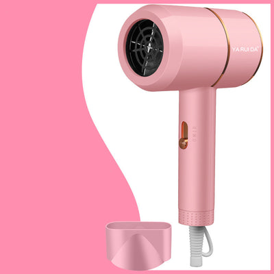 White portable folding hair dryer with rose gold accents and a nozzle attachment, shown with its base. - Image 4