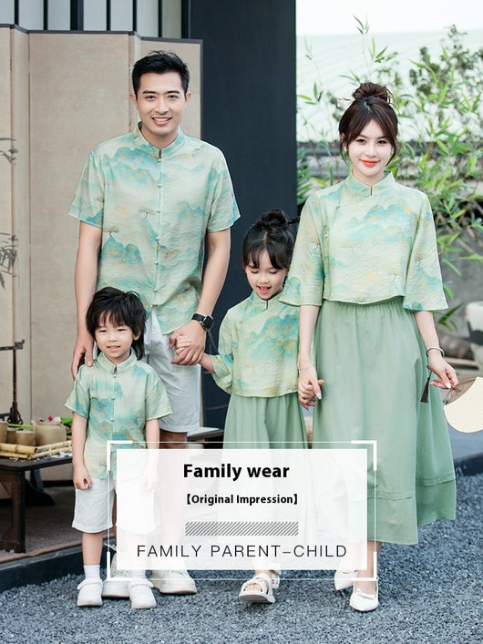 Mother and daughter in matching light green Chinese style cheongsam suits with patterned tops and solid skirts. - Image 7