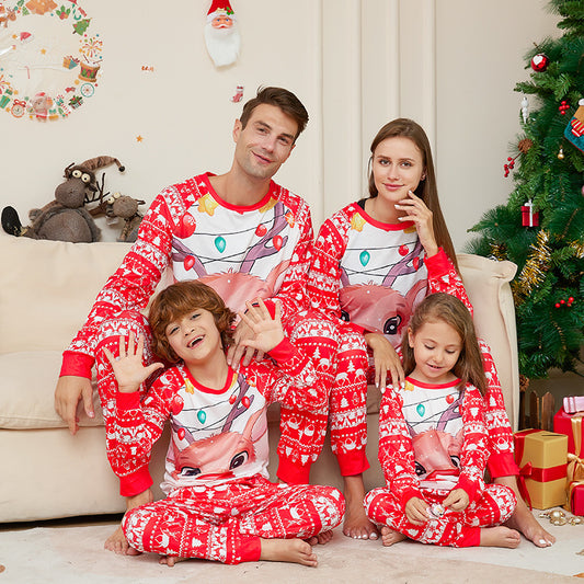 Man wearing a red and white Christmas pajama set with a reindeer graphic and fair isle pattern.